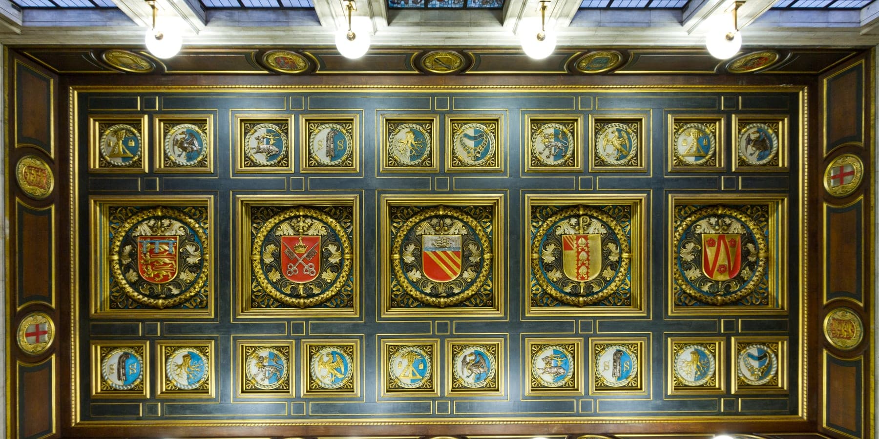 The gilded entrance ceiling of Manchester Central Library, panelled with civic coats of arms