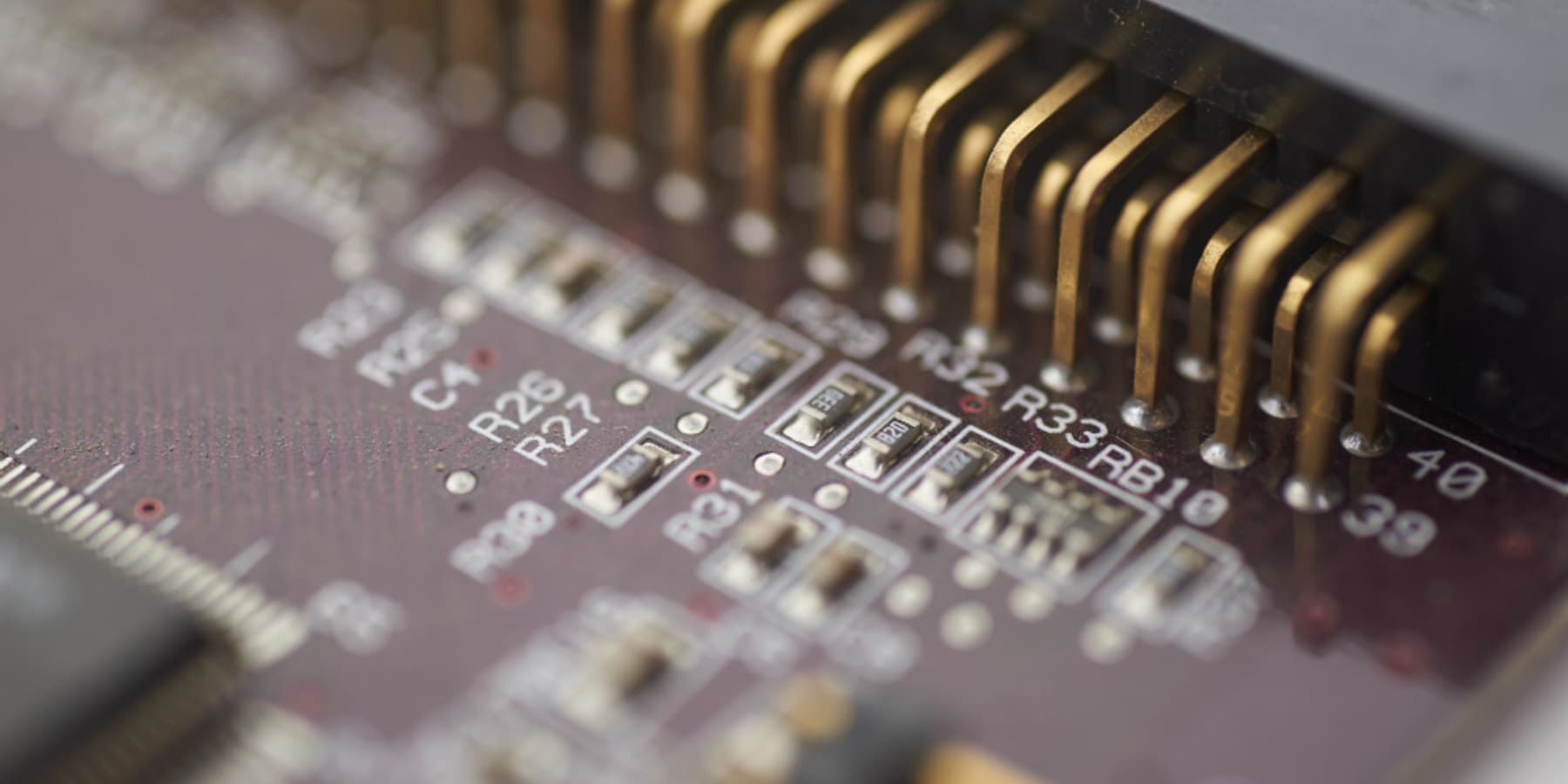 A close view of a circuit board, its gold contacts catching the light
