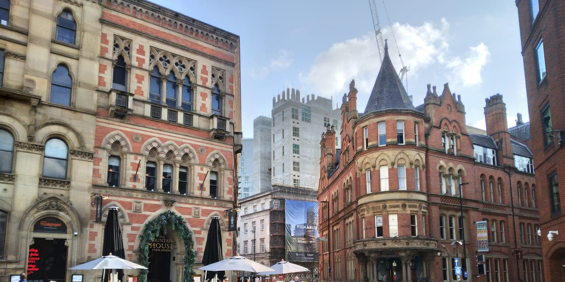 Victorian buildings around Albert Square in Manchester city centre on a bright afternoon